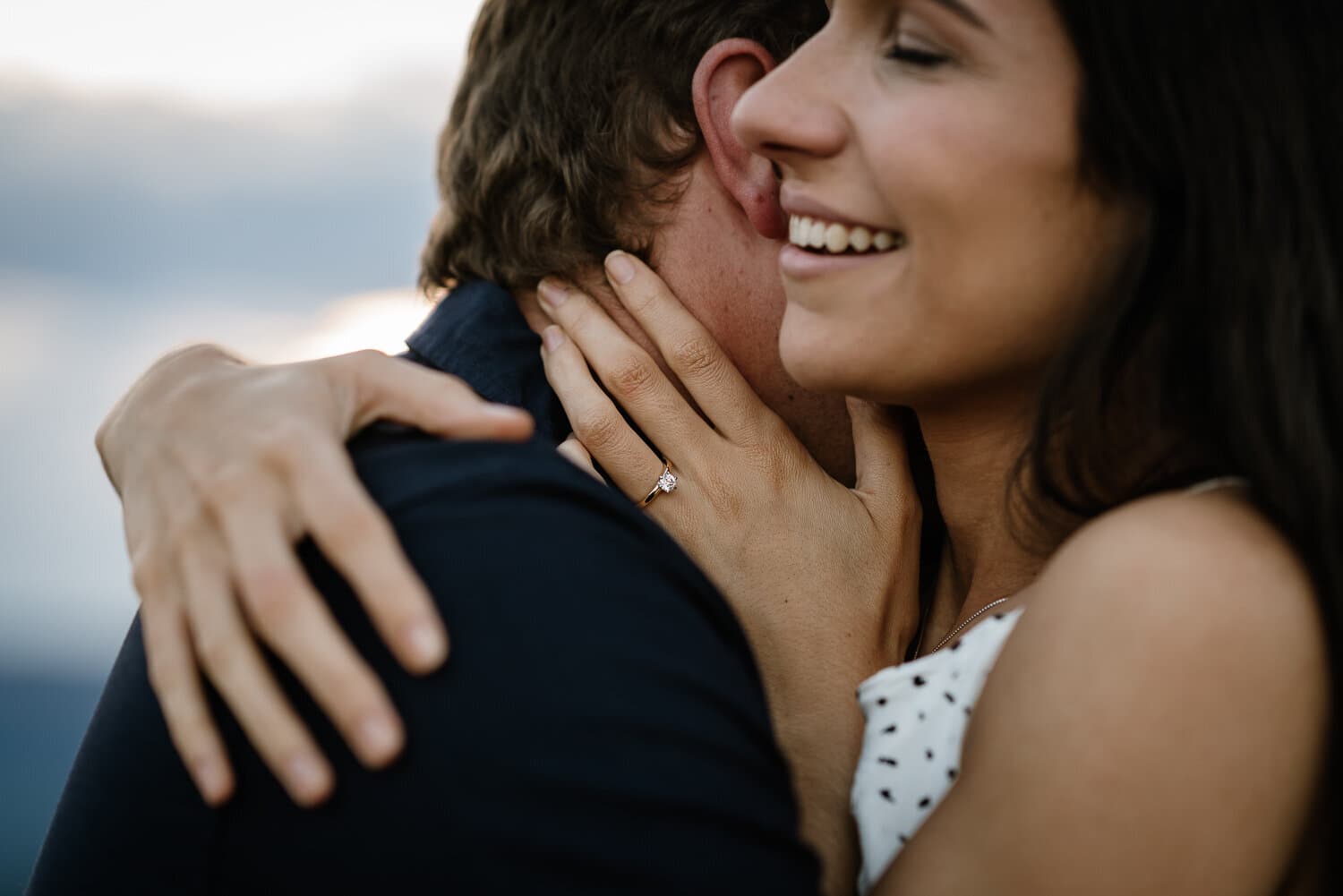 Close frame of a couple embracing with a ring resting on a shoulder