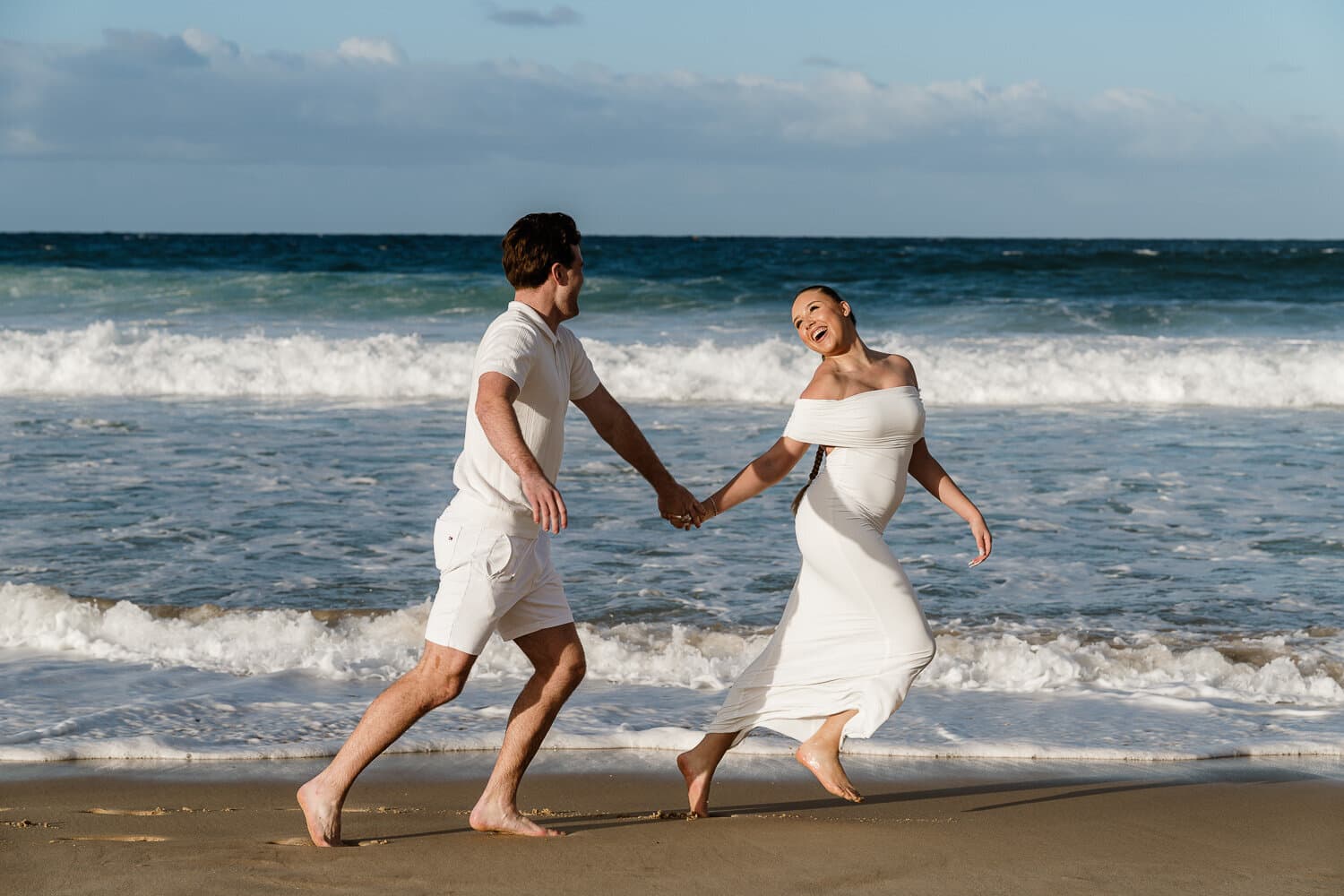 Couple running through the shallows on a Sydney beach