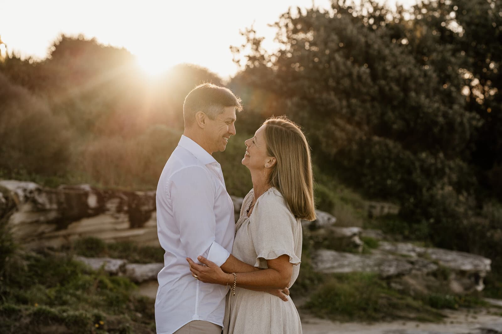 Couple embracing in golden light on a coastal headland