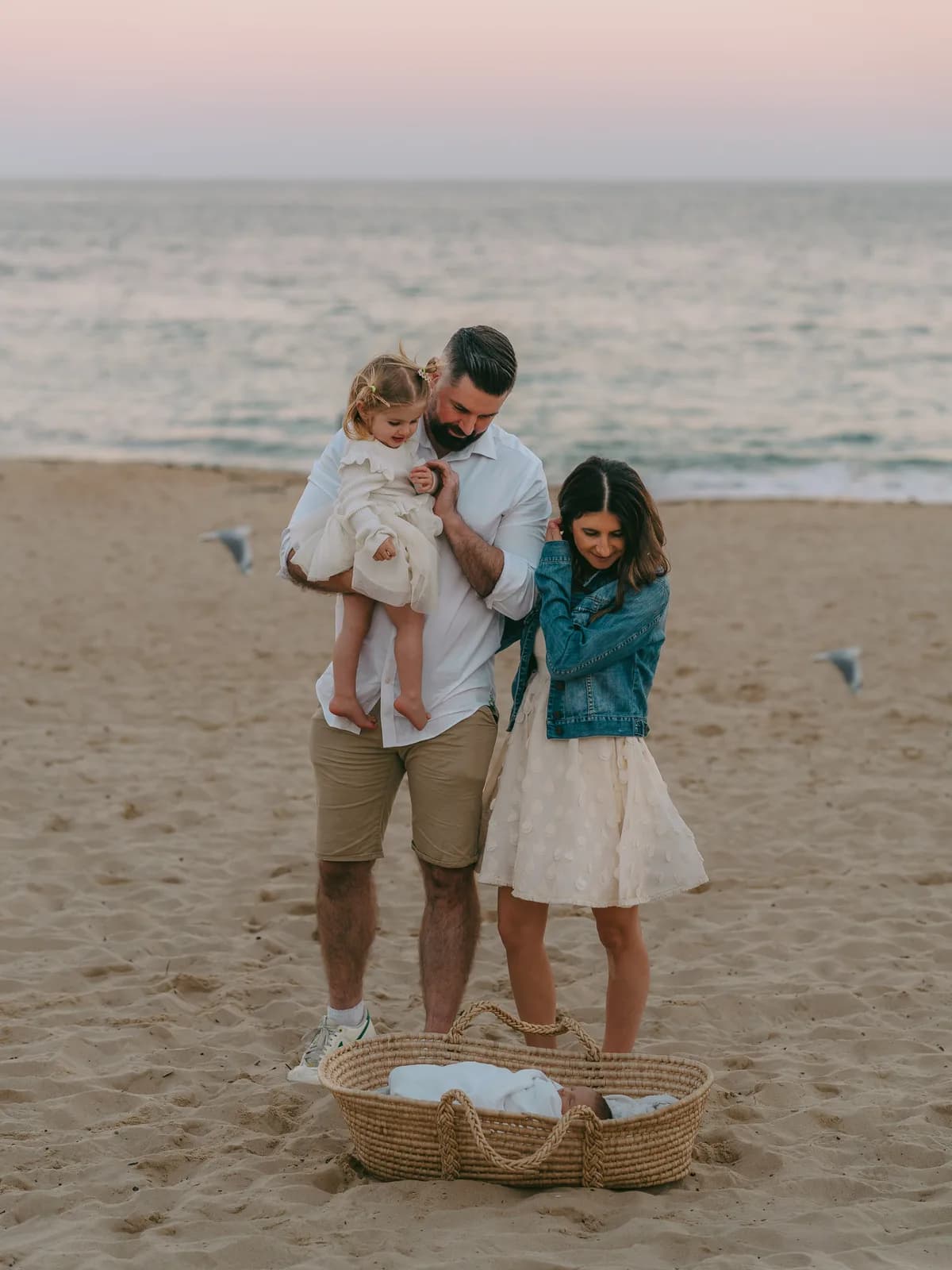 Family of 4 together on the sand at dusk during a Sydney beach photoshoot