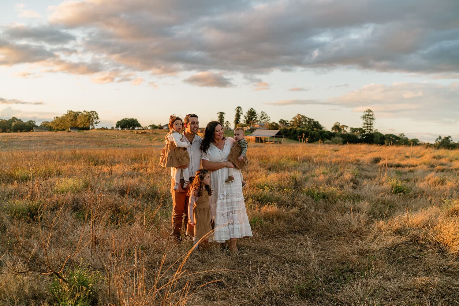 Family standing together in an open paddock as the light drops