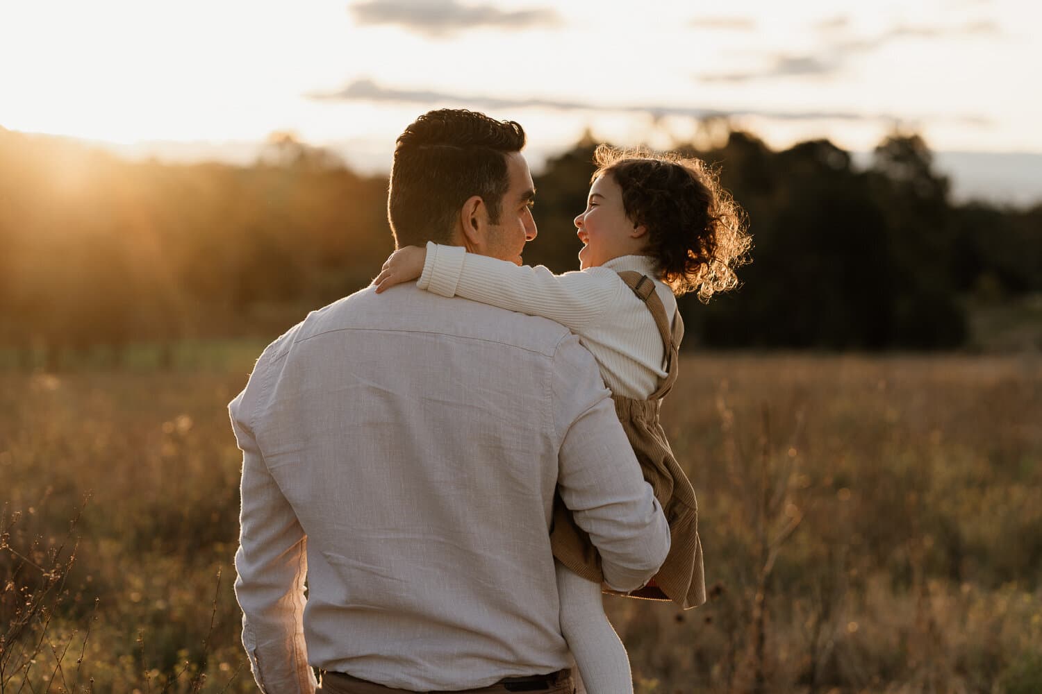 Couple photographed in a golden field at sunset by Nerissa J Photography