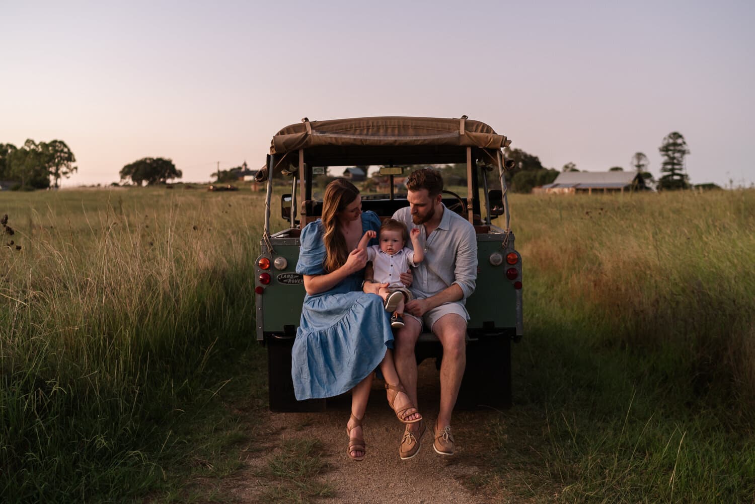 Family gathered at the back of a ute in a paddock