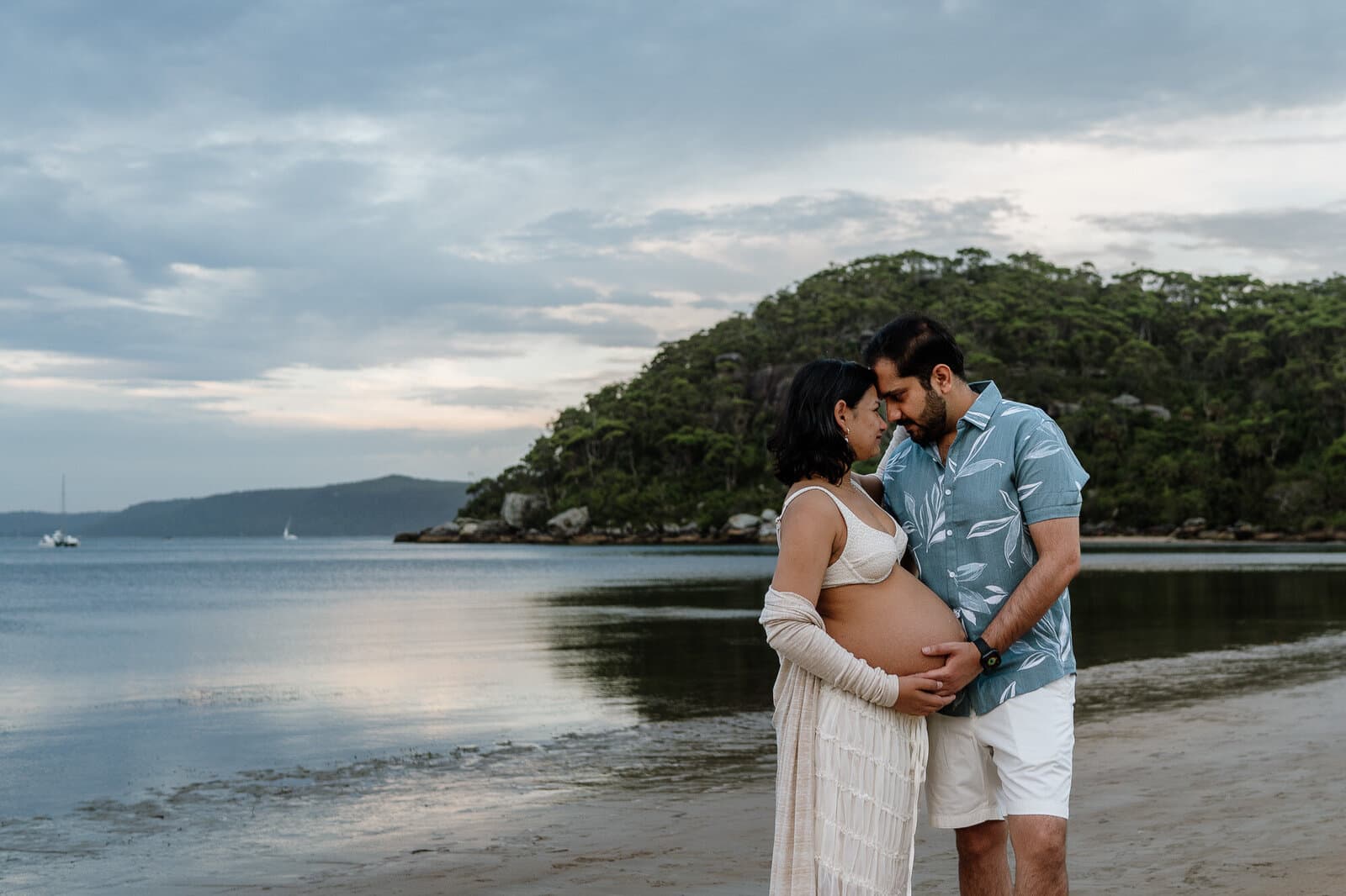 Expecting couple on a Sydney beach at dusk