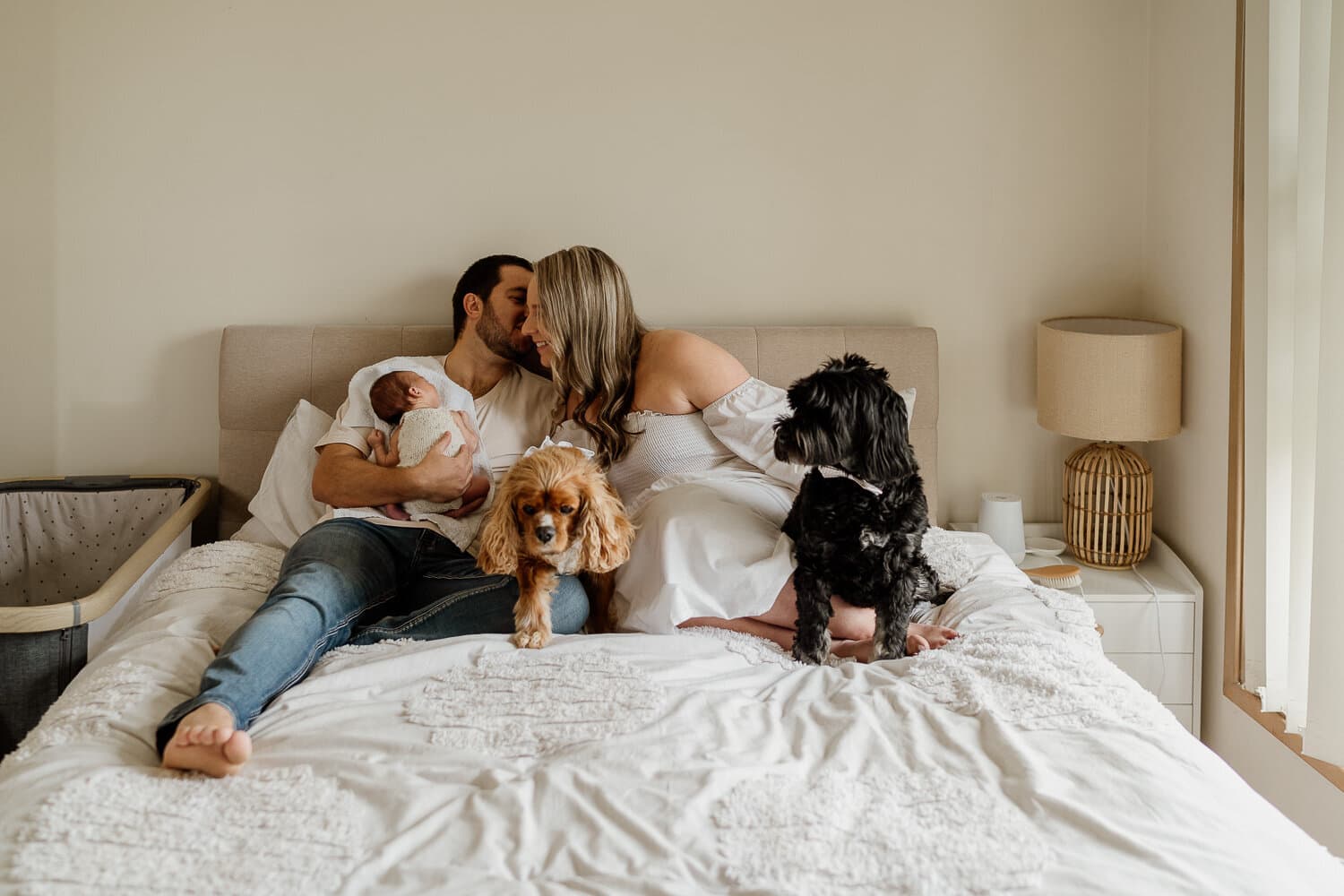 Family together on the bed during a lifestyle newborn session at home