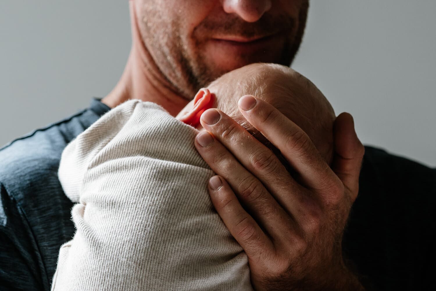 Father cradling his newborn against his chest