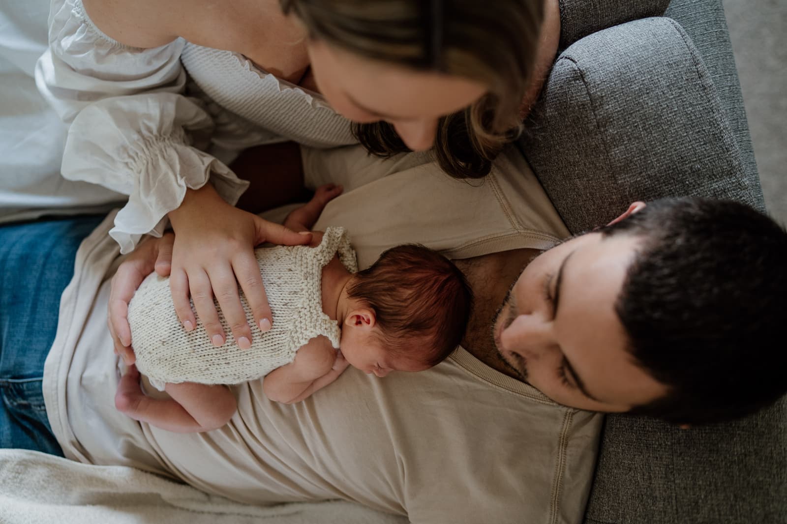 New family together in an open field at sunset with their newborn