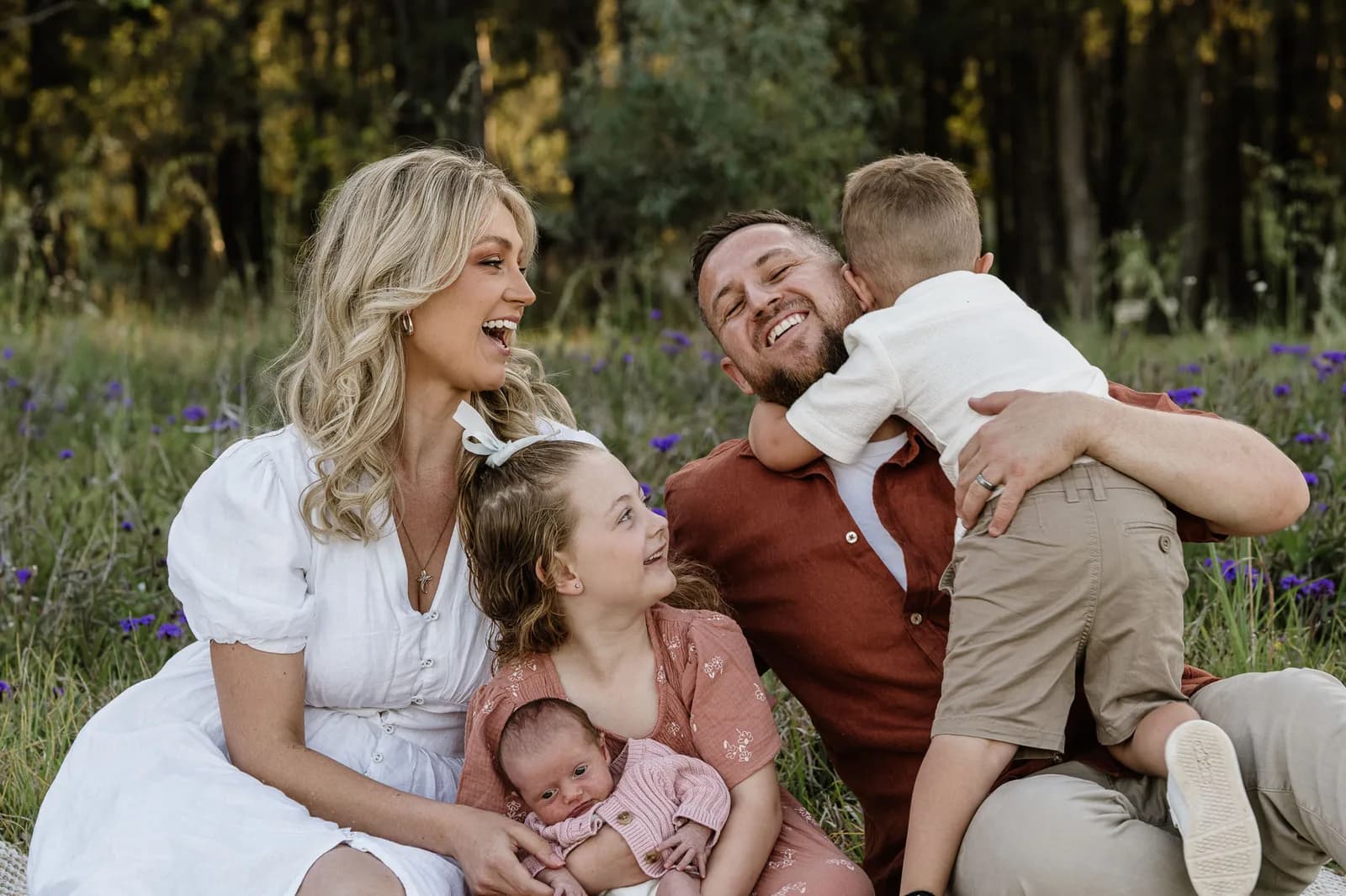 Family of 5 together on the grass with their newborn during a Sydney newborn session