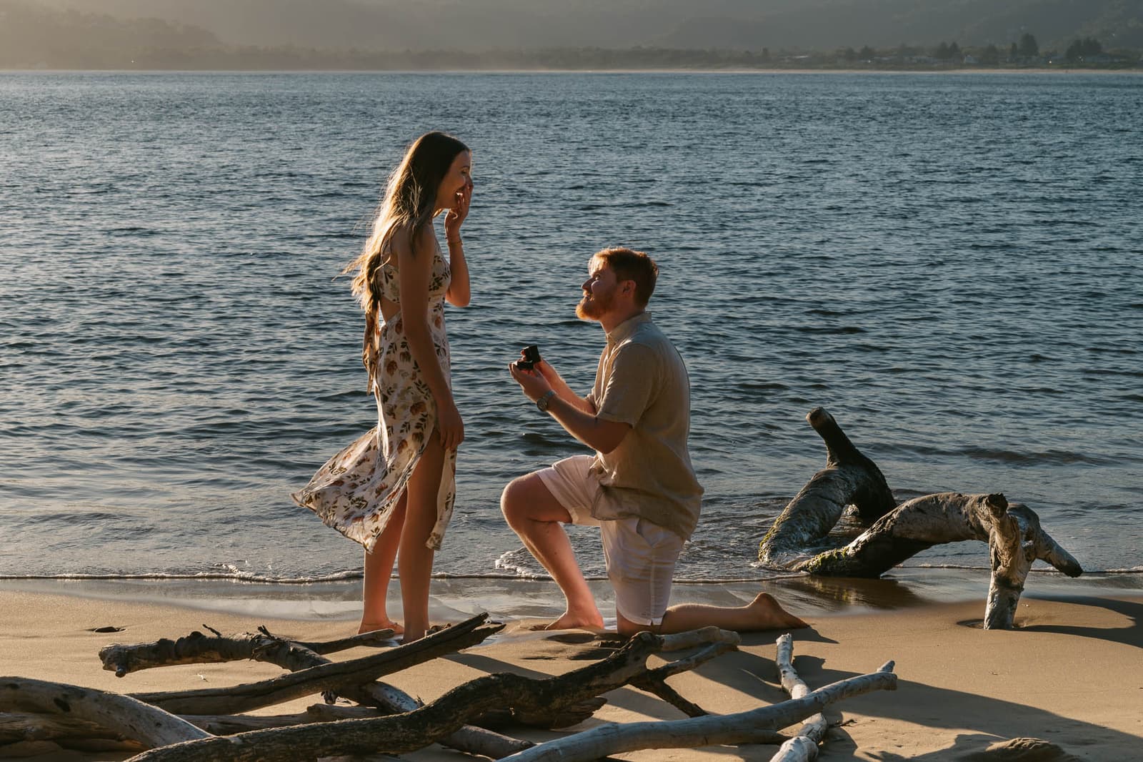 The moment he drops to one knee on the driftwood at the water's edge