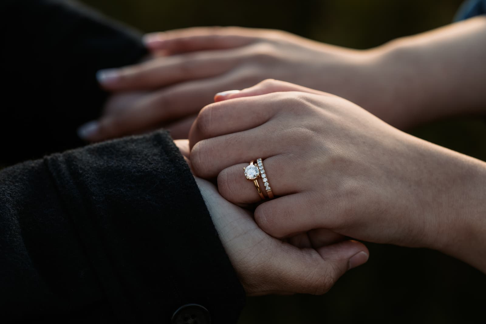 Close-up of the engagement ring on her hand, held in his