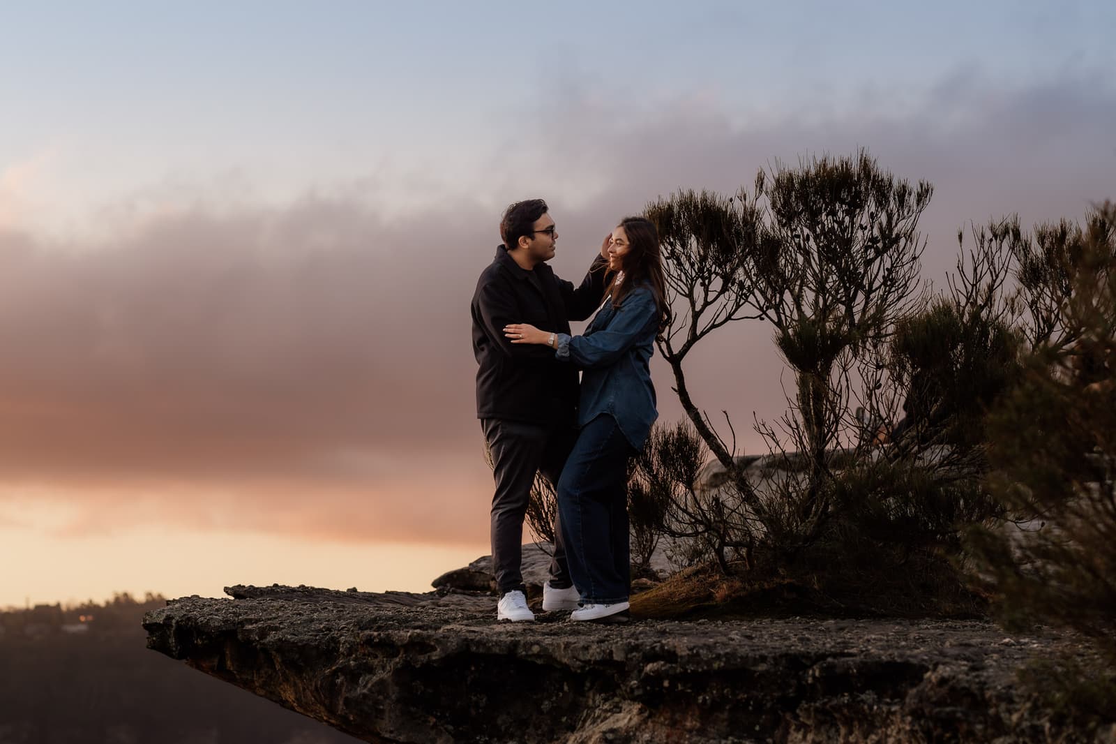 He drops to one knee on a Blue Mountains clifftop under a pink sky