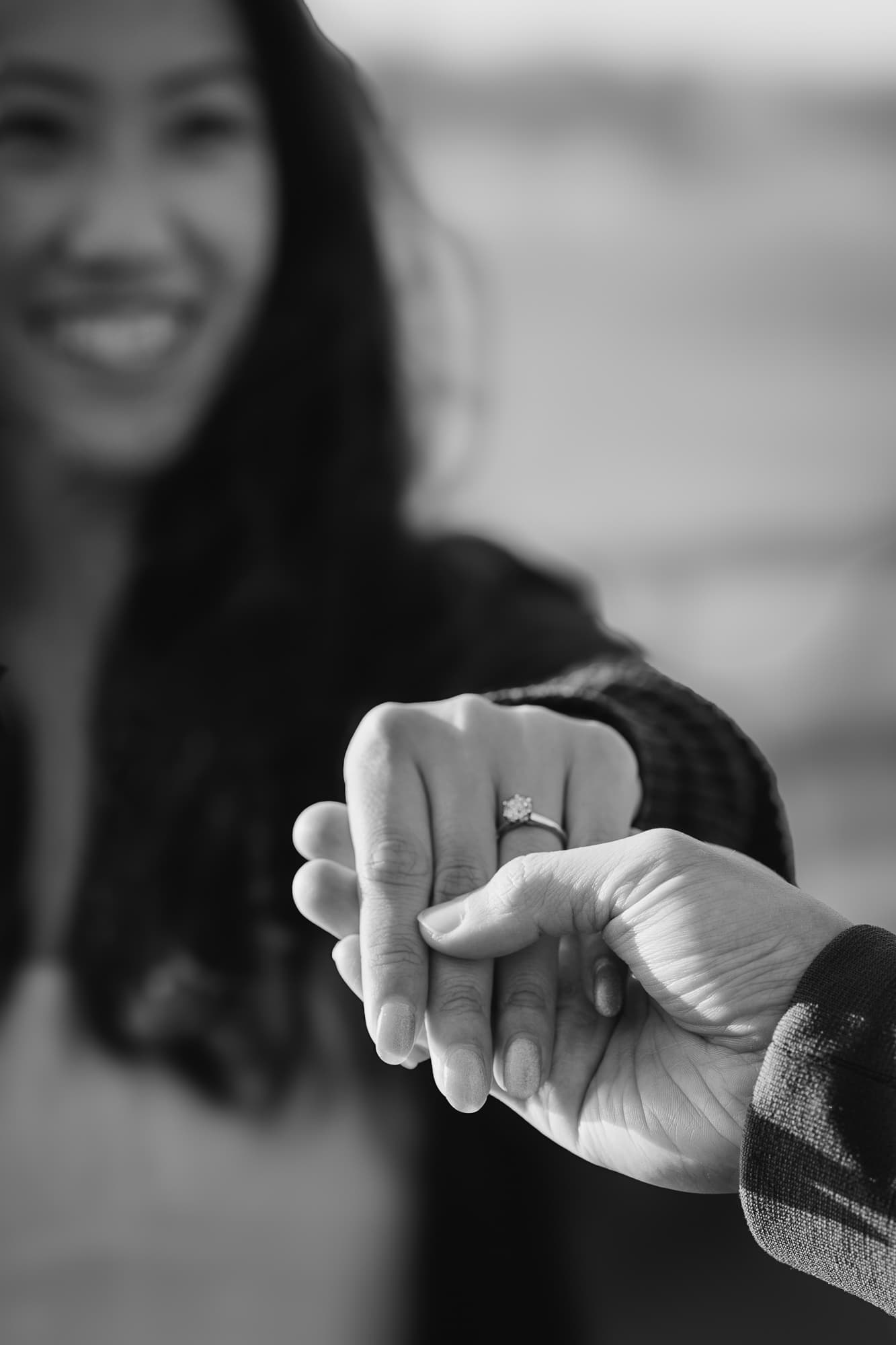 Black and white portrait of her smiling with the new ring on her hand