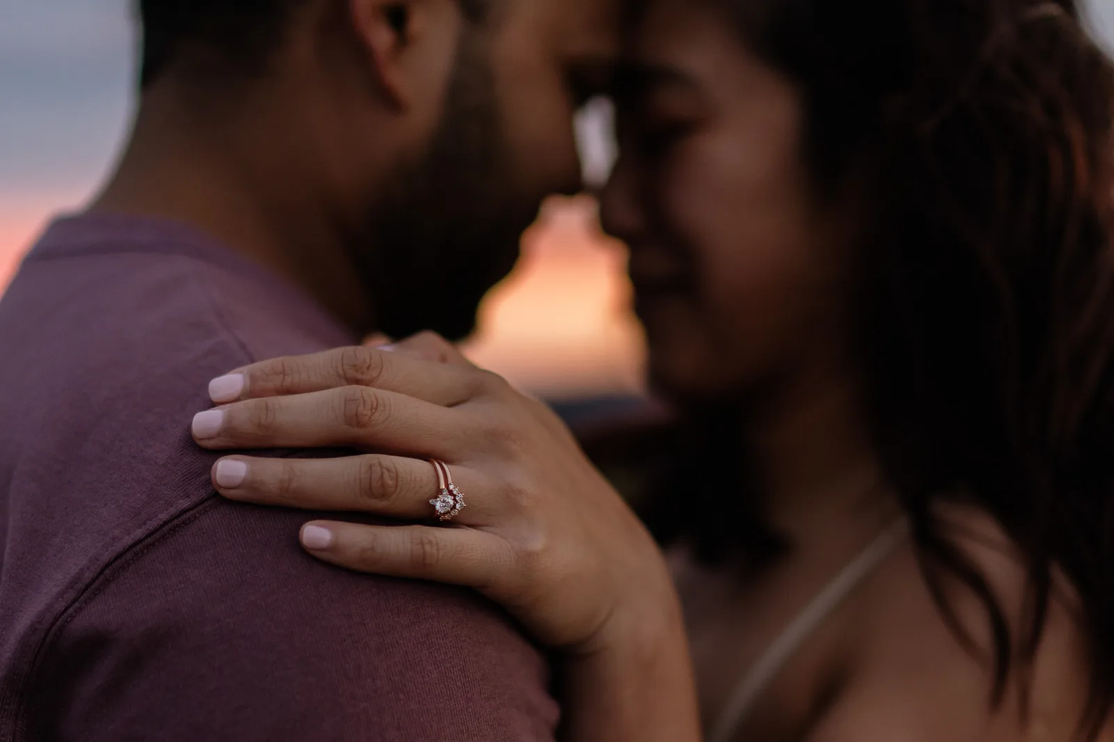 Close frame of the engagement ring as the couple hold each other after the proposal