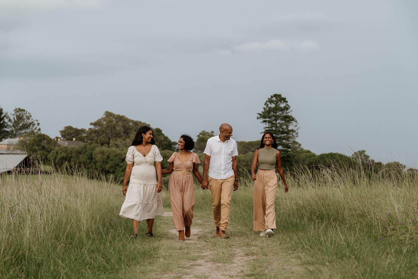 Family walking together through long grass at dusk near Kellyville