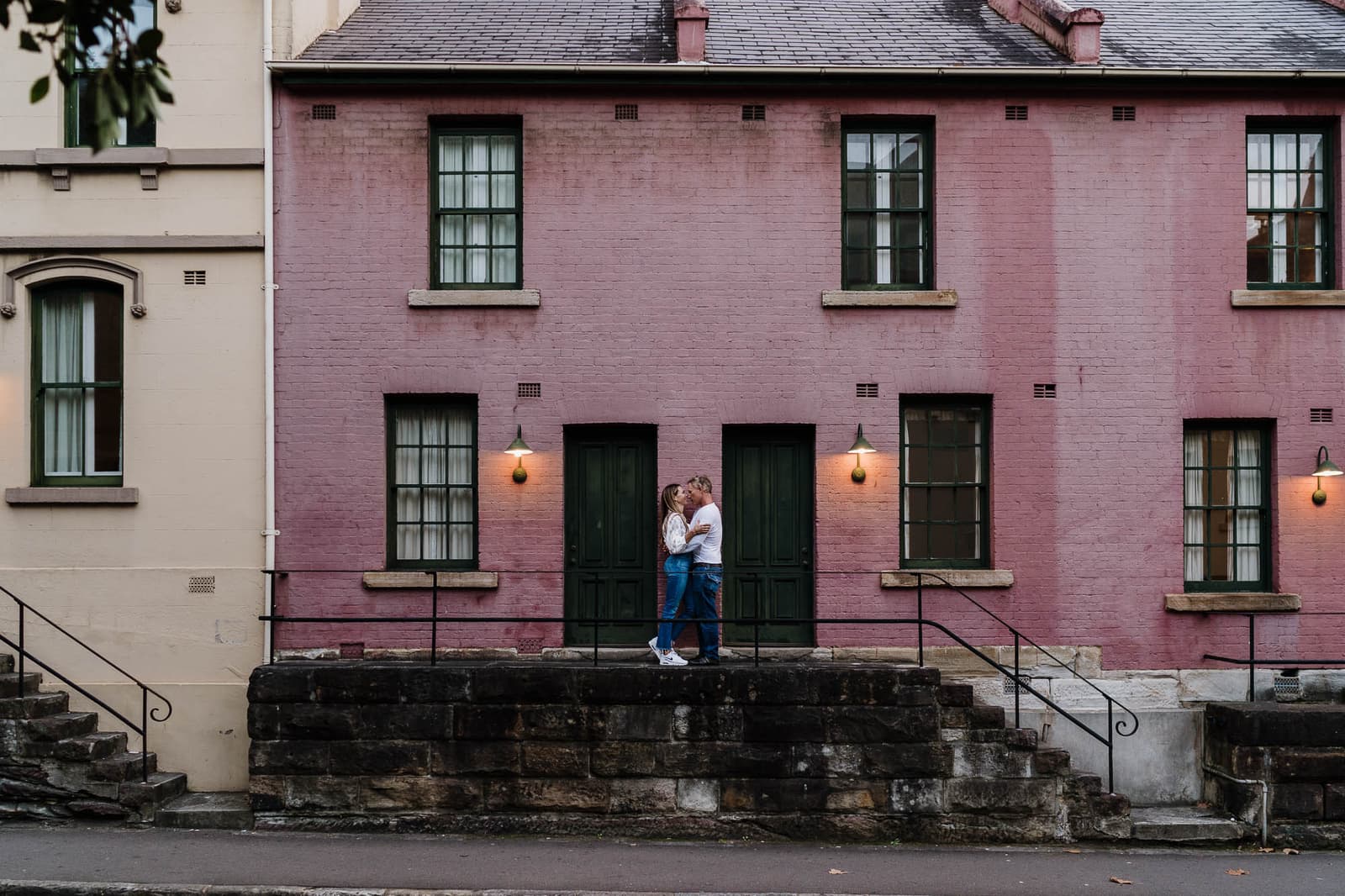 Couple on the steps of a pink terrace house during a Sydney couples session