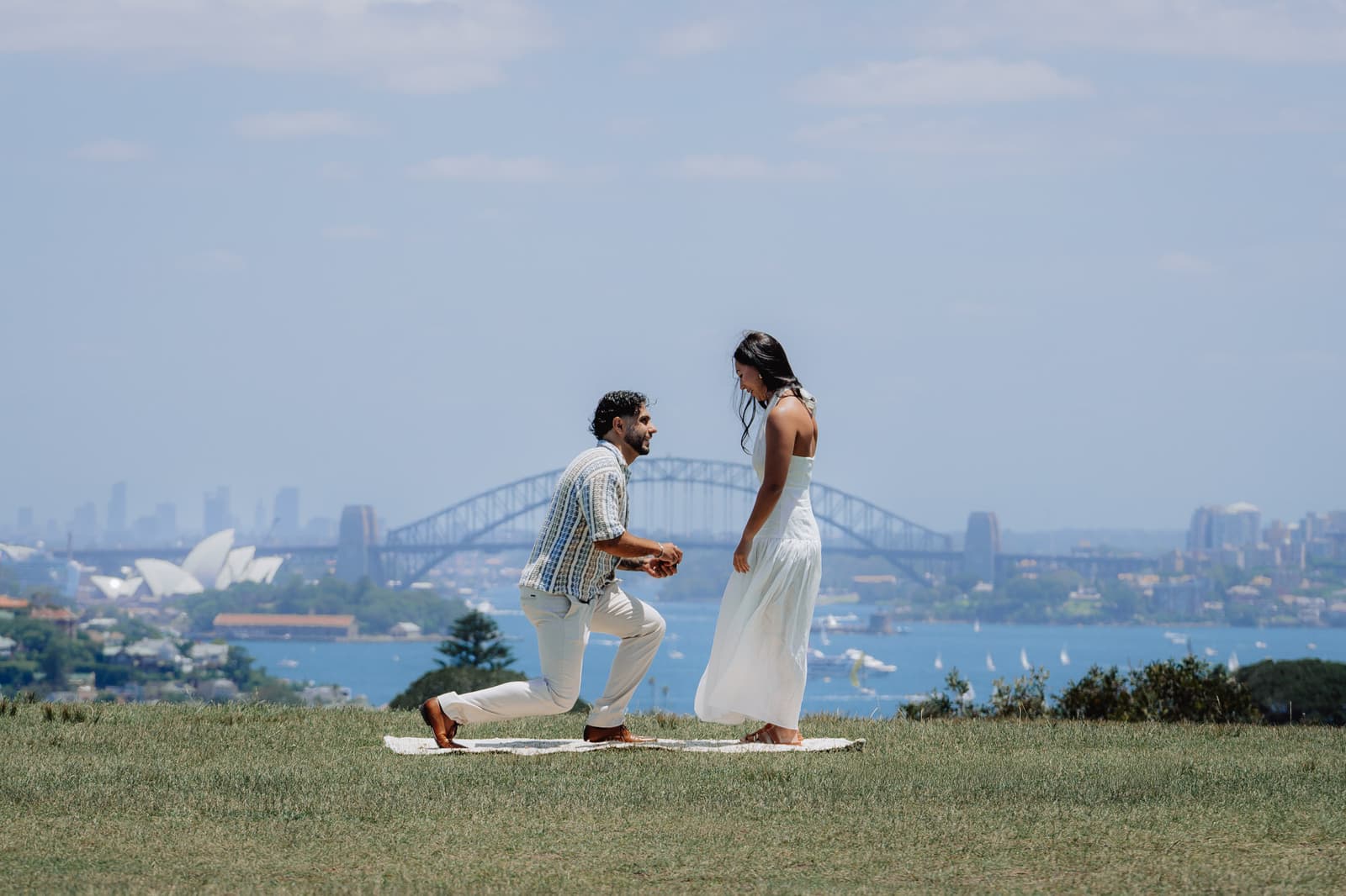 Surprise proposal on the grass above Sydney Harbour with the Opera House behind